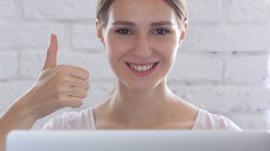 Başparmak yukarıya onun masasına oturan yaratıcı kadın tarafından