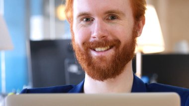 Kırmızı saç Office kamerada doğru gülümseyen adam