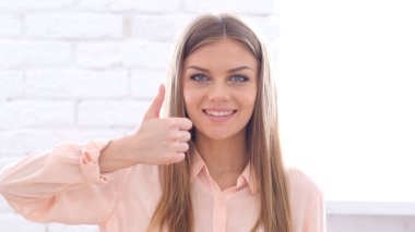 Başparmak yukarıya kameraya arayan genç kadın tarafından