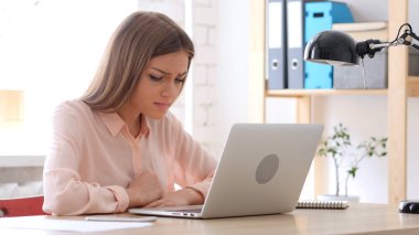 Yorgun yaratıcı dizüstü bilgisayarda çalışan kadın