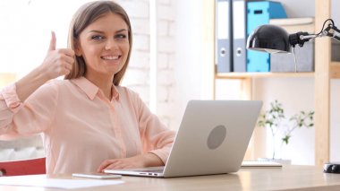 Başparmak yukarıya ofisinde oturan yaratıcı kadın tarafından