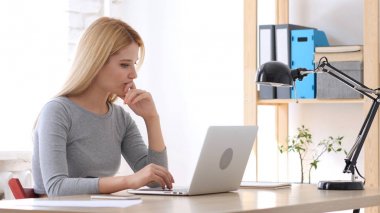 Dizüstü bilgisayarda çalışan hayal kırıklığına uğramış genç kadın