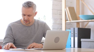 Orta yaşlı adam okuma ofisinde işyerinde