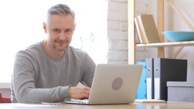 Orta yaşlı adam kamera doğru gülümseyen