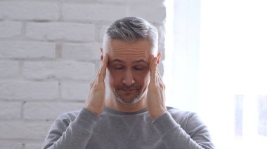 Baş ağrısı, orta yaşlı adam ofiste çalışan sinirli