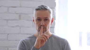 Sessizlik ofisinde oturan orta yaşlı adam tarafından el hareketi