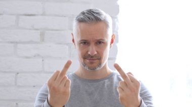 Orta yaşlı adam orta parmak, ofiste oturan gösterilen