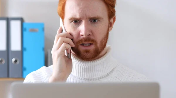 Крупний людина з червоні волосся говорити на телефон, обговорюючи — стокове фото