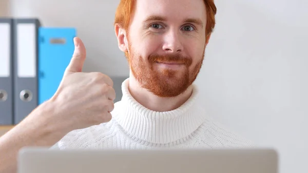 Pulgares hacia arriba por el hombre con el pelo rojo y la barba en el trabajo —  Fotos de Stock