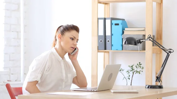 Frau nimmt Ruf nach Arbeit an, spricht mit Kunden — Stockfoto