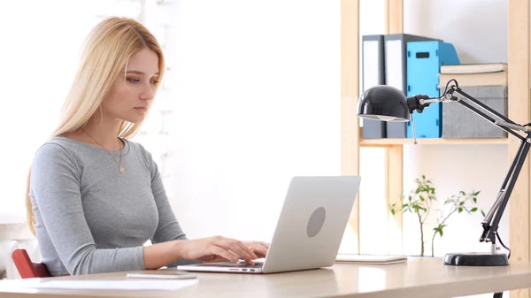 Junge Frau arbeitet im Büro am Laptop — Stockfoto