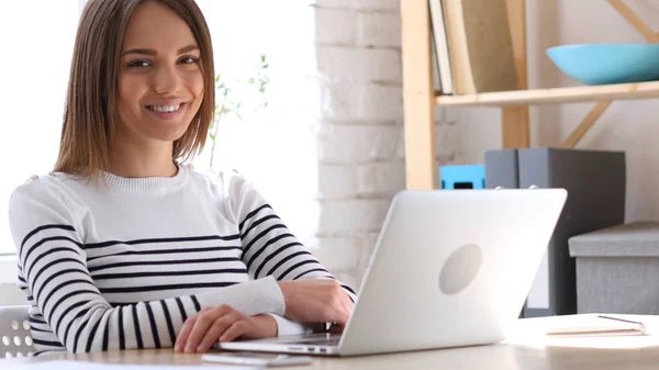 Lächelnde schöne junge Frau bei der Arbeit — Stockfoto