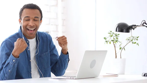 Afro-American Man lyssnar musik på hörlurar i Office — Stockfoto