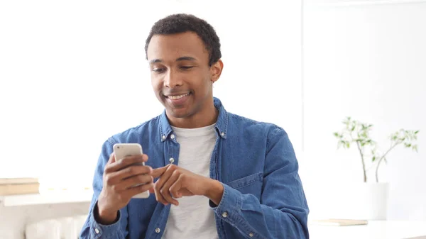 在智能手机上进行在线浏览的美国黑人年轻人 — 图库照片