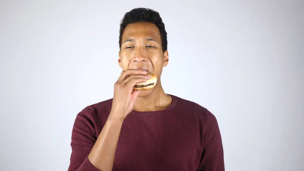 Burger essen, hungrigen jungen afroamerikanischen Mann kauen — Stockfoto