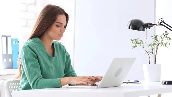 Schöne Frau arbeitet im Büro am Laptop — Stockfoto