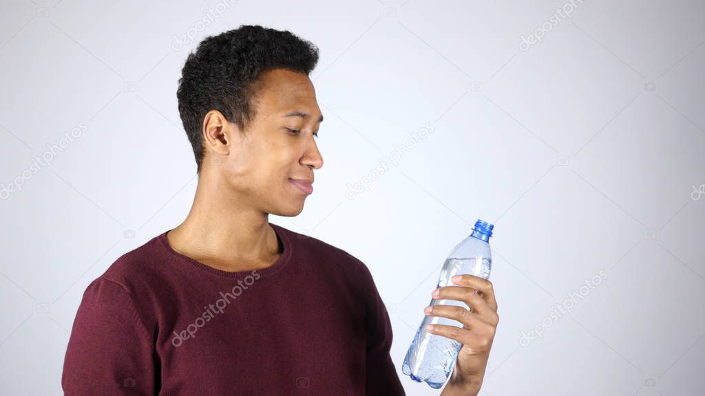 Afro-American Man Holding Bottle of Distilled Water, White Background