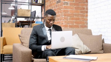 Siyah iş adamı dizüstü bilgisayarla çalışıyor