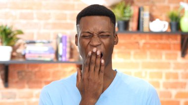 Uyuklayan yorgun siyah genç adam esniyor