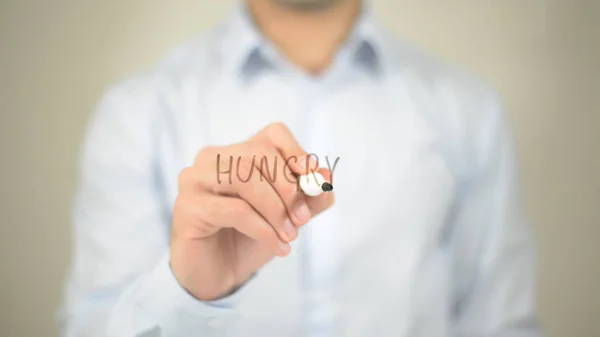 Hambriento, hombre escribiendo en pantalla transparente — Foto de Stock