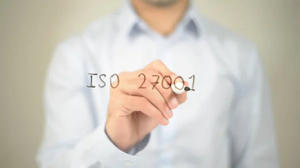 ISO 27001, man writing on transparent screen — стоковое фото