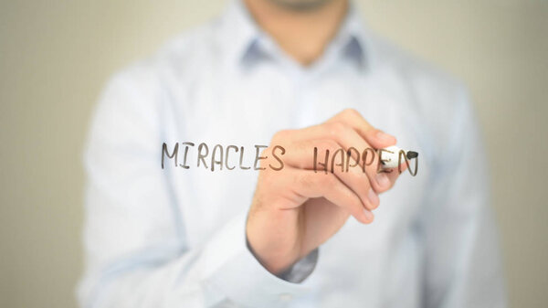 Miracels Happen , man writing on transparent screen