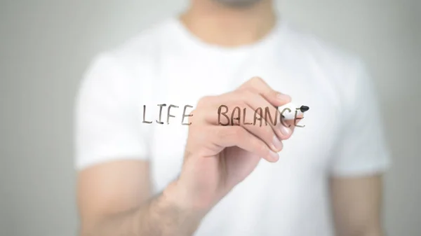 Life Balance, man writing on transparent screen