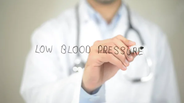 低的血压，医生在透明屏幕上写字 — 图库照片