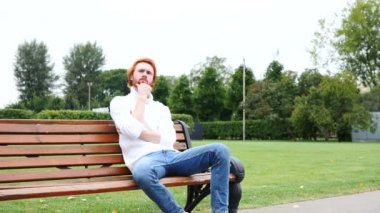 Tezgah, kırmızı saç ve sakal parkta oturan adam