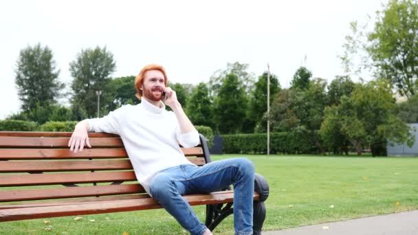 Attending Phone Call, Communicating, Sitting on Bench in Park — Stock Video