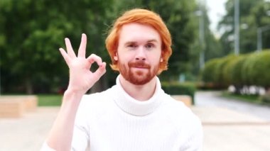 Tamam işareti kırmızı saçlar, açık olan adam