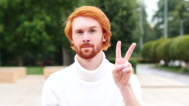 Zafer işareti kırmızı saçlar, açık olan adam tarafından