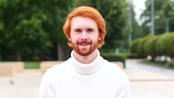 Портрет улыбающегося человека с рыжими волосами, на открытом воздухе — стоковое видео