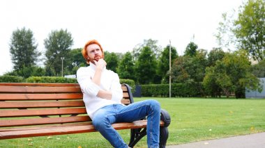 Tezgah, kırmızı saç ve sakal parkta oturan adam