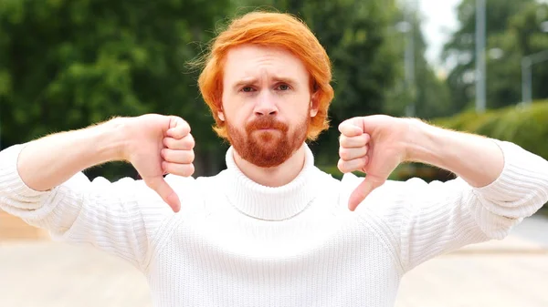 Человек с рыжими волосами на улице сносит пальцы обеих рук — стоковое фото