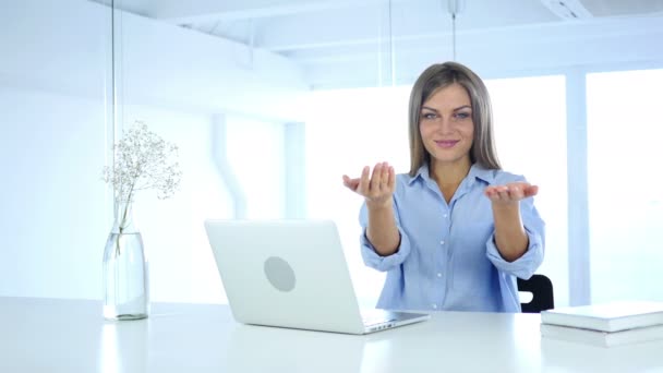Женщина в офисе приглашает клиентов обеими руками — стоковое видео