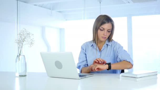 사무실에 앉아 Smartwatch를 사용 하 여 젊은 여자 — 비디오