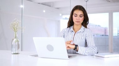 Genç kadın Smartwatch, oturma içinde yazıhane kullanma