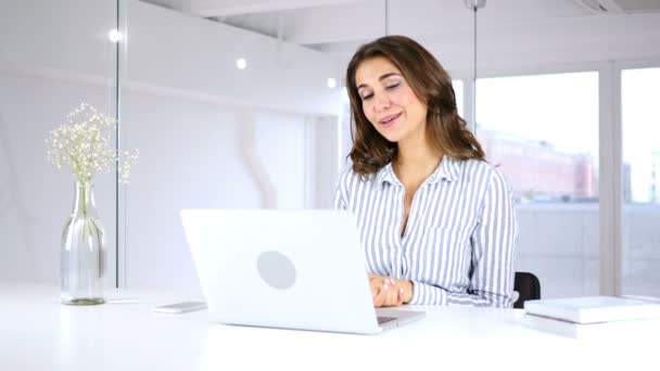 Chat vidéo sur ordinateur portable par femme assise au bureau pour le travail — Video