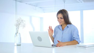 Laptop için çalışma ofisinde oturan bir bayan tarafından görüntülü sohbet