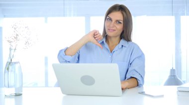 Başparmak aşağı, sinirli kadın ofiste otururken jest