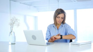 Genç kadın Smartwatch, oturma içinde yazıhane kullanma