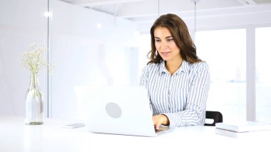 Laptop ofiste çalışan olumlu genç kadın