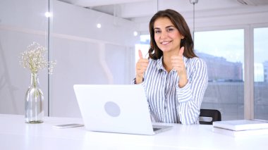 Her iki el başparmak yukarıya jest kadın onun iş yerinde tarafından