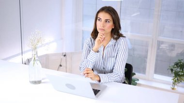 Dalgın kadın düşünme ve planlama dizüstü bilgisayarda çalışırken