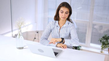 Müşteri için iş yerinde bekliyor, zaman seyretmek kontrol kadın