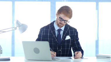 Kızıl saçlı işadamı yazılı olarak Office, belgeleri