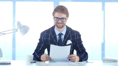 Pozitif adam okuma belgeleri iş yerinde, gülümseyen