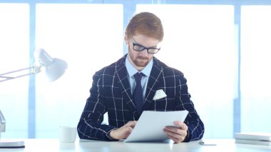 Ciddi adam okuma Douments iş, kırmızı saçlar