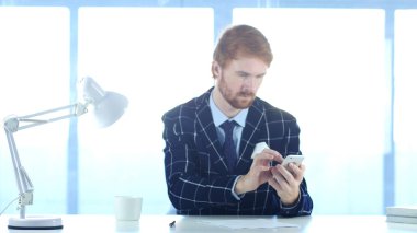 Çevrimiçi, kırmızı tüyler adamla gezinme için Smartphone kullanarak